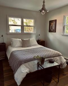 a bedroom with a large bed and two windows at Chic Dunes Cottage with HOT TUB near Warren Dunes 