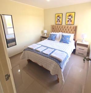 a bedroom with a large bed with blue pillows at Apartamento Premium frente a Universidad San Marcos para 4 pers en lima in Lima +17 photos