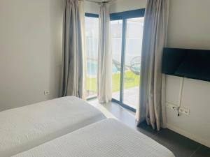 a bedroom with a bed and a large window at Villa Neo - Private Pool - 8 minutes Corralejo, mini Gym!! in Villaverde