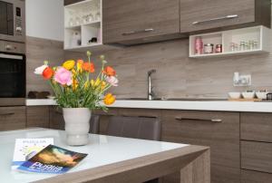 a vase of flowers on a table in a kitchen at Bella Puglia Bed and Breakfast in Ruvo di Puglia +8 photos