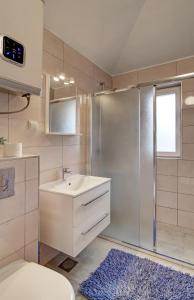 uma casa de banho com um lavatório e um chuveiro em Apartments Corner em Dubrovnik