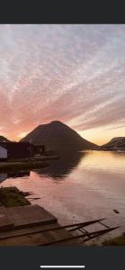 a view of a body of water with a mountain at Small renovated boathouse down by the sea in Klaksvík
