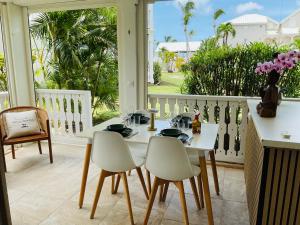 a white table and chairs in a room with a balcony at Appartement Le Colibri in Baie Nettle