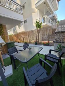 un patio con mesa y sillas en el césped en Luxury Angel Apartments 1, en Paralia Katerinis