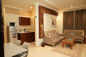 a kitchen and a living room with a couch and a table at ELGOUN Serviced apartments in Riyadh