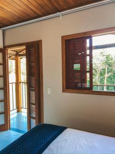 un dormitorio con una cama y una ventana en Pousada Chalé Santa Teresa, en Santa Teresa