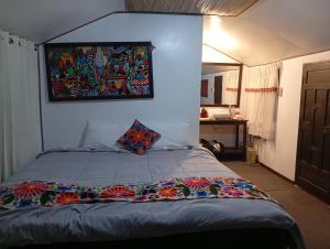 a bedroom with a bed with a painting on the wall at Titicaca posada del sol lodge in Puno