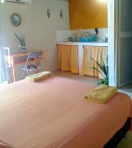 a bedroom with a bed with two towels on it at Perth House Taganga in Taganga