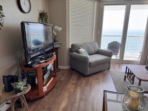 a living room with a tv and a couch and a chair at Sunrise Pointe 11F Condo in Myrtle Beach