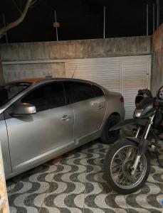 a silver car parked in a garage next to a motorcycle at Casa Completa SJ - 6KM in Campina Grande