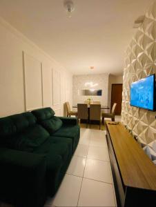 a living room with a green couch and a table at Casa Completa SJ - 6KM in Campina Grande