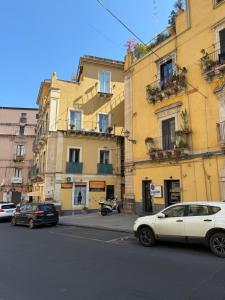 a white car parked in front of buildings on a street at Aradas Home in Catania