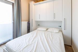 a bedroom with a white bed with two pillows at Shangri-La 0202 G in Sint-Idesbald