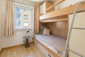 ein kleines Schlafzimmer mit einem Etagenbett und einem Fenster in der Unterkunft Arian 0401 in Saint-Idesbald