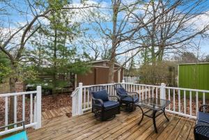 a deck with two chairs and a table on it at Cozy Cottages Green Cottage Hot tub-Town in Saugatuck