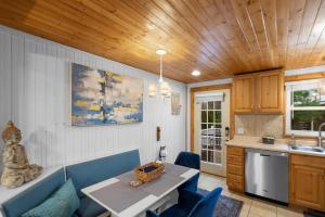 a kitchen with a table and blue chairs in a room at Cozy Cottages Green Cottage Hot tub-Town in Saugatuck +11 photos