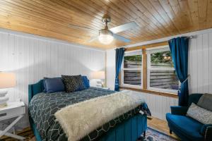 a bedroom with a bed and a blue chair at Cozy Cottages Green Cottage Hot tub-Town in Saugatuck