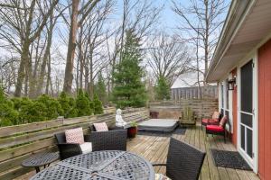 a deck with chairs and tables on a house at Cozy Cottages Red Cottage Hot tubTown in Saugatuck