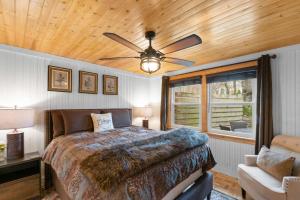 a bedroom with a bed and a ceiling fan at Cozy Cottages Red Cottage Hot tubTown in Saugatuck
