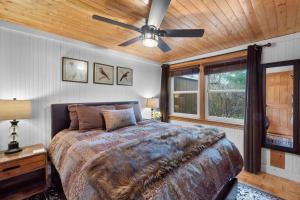 a bedroom with a bed and a ceiling fan at Cozy Cottages Brown Cottage Hot tubTown in Saugatuck