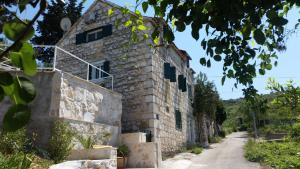an old stone building with a dirt road at Holiday Home Bobovisca in Ložišće