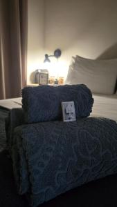a bed with a blue blanket and a picture on it at Quarto exclusivo, próximo a Dutra e Vale Sul Shopping em SJCampos-SP in São José dos Campos