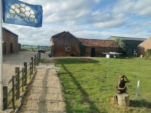 una bandera colgada en una valla junto a un edificio en Beachlife Dome with Hut & Hot Tub in Private Courtyard, en Snelland 3 fotos más