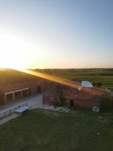 una vista de un edificio con la puesta de sol en el fondo en Beachlife Dome with Hut & Hot Tub in Private Courtyard, en Snelland
