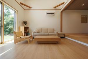 a living room with a couch and a coffee table at New Villa Natural Q 城ケ崎海岸 伊豆高原 in Ito