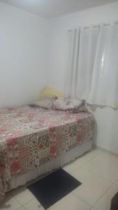 a bed in a room with a blanket on it at Casa São João in Campina Grande