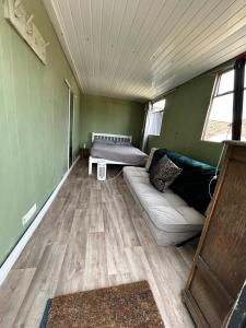 una sala de estar con un sofá y una cama en Beachlife Dome with Hut & Hot Tub in Private Courtyard, en Snelland