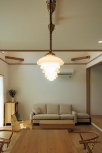 a living room with a couch and a chandelier at 新築2年目Resort & Villa Natural Q 城ケ崎海岸と伊豆高原の間 in Ito