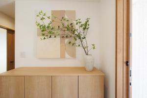 a vase on top of a wooden cabinet with a plant at New Villa Natural Q 城ケ崎海岸 伊豆高原 in Ito