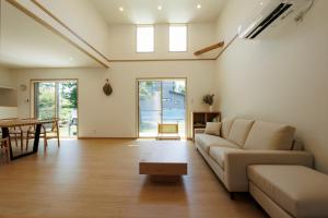 a living room with a couch and a table at New Villa Natural Q 城ケ崎海岸 伊豆高原 in Ito
