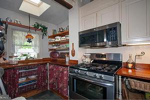a kitchen with a stove and a microwave at Historic Main Street Getaway 