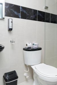 a bathroom with a toilet and a phone on the wall at 33 HOTEL BOUTIQUE in Medellín +51 photos