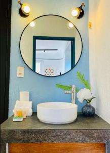 a bathroom with a sink and a mirror at Bugambilia Azul Centro Oaxaca in Oaxaca City