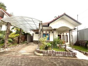 a white house with an arch over a driveway at SF Homey Galaxy in Cikundul