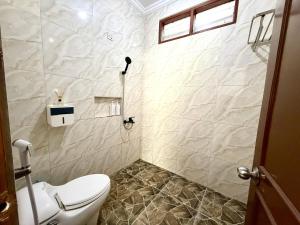 a bathroom with a white toilet and a shower at SF Homey Galaxy in Cikundul +32 photos
