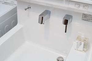 a bathroom with two faucets on a counter at KOTI Hakata in Fukuoka +15 photos