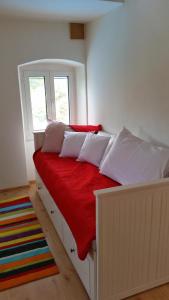 a bedroom with a white bed with red sheets and pillows at Holiday Home Bobovisca in Ložišće +31 photos
