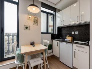 a kitchen with white cabinets and a wooden table at Feel Porto Wine Essence IV in Vila Nova de Gaia