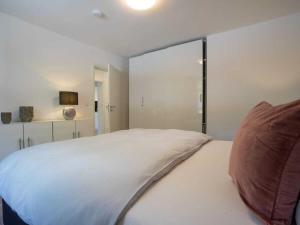 a bedroom with a white bed and a large window at 1-bedroom holiday apartment in Oberstdorf