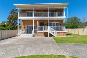 una casa in mattoni con balcone sul vialetto di Vincentia Breeze by Experience Jervis Bay a Vincentia