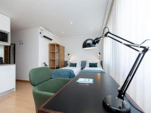 a hotel room with a bed and a desk and a room at Feel Corporate Housing Marquês Garden View in Porto