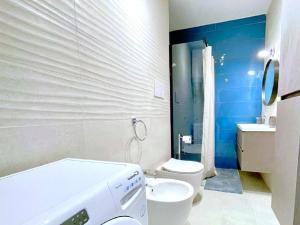 a bathroom with a white toilet and a blue wall at Apartment in Porto Santa Margherita by the Sea in Porto Santa Margherita di Caorle