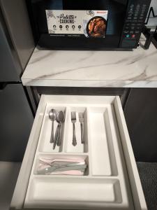 a white tray with utensils on a table at Horizon Staycation w WiFi in Sepang