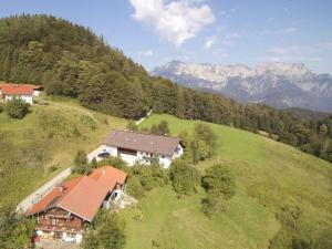 an aerial view of a house on a hill with mountains at 1-bedroom holiday apartment in Berchtesgaden