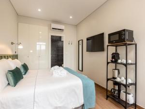 a bedroom with a white bed and a tv at Feel Porto Wine Essence II in Vila Nova de Gaia