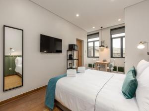a bedroom with a large white bed and a tv at Feel Porto Wine Essence II in Vila Nova de Gaia